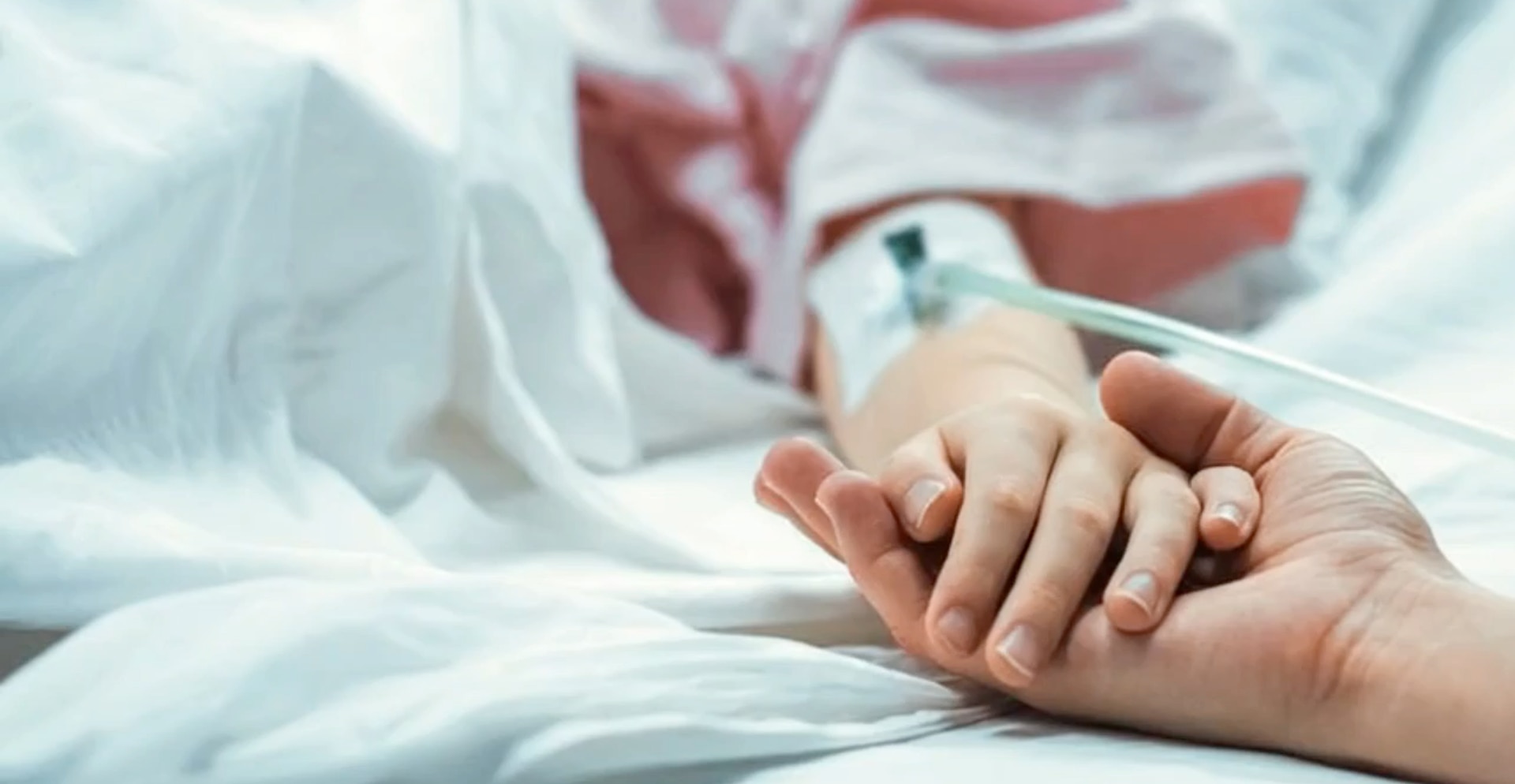 Patient in Bed Holding Hands of Carer