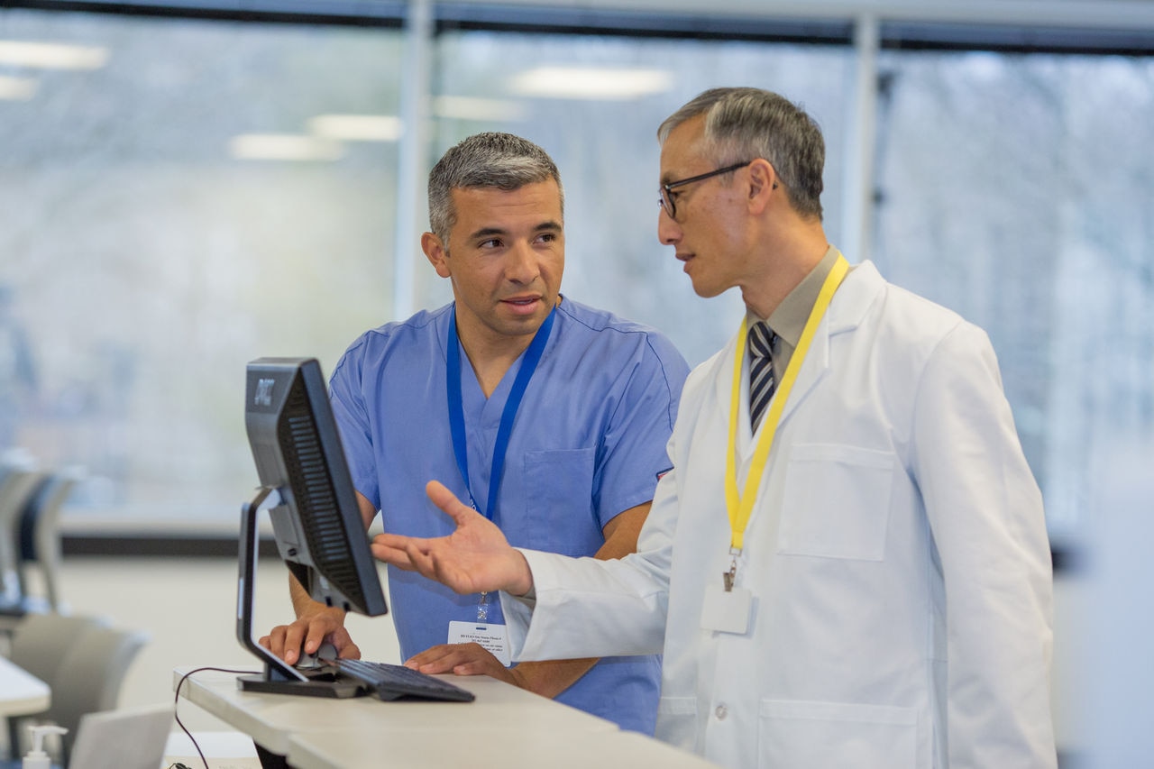 Medical professionals discussing patient data at workstation