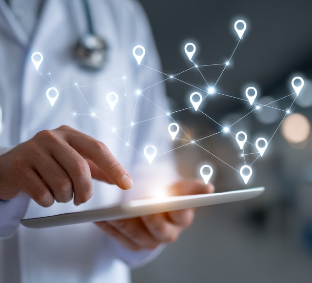Doctor using digital tablet with network map