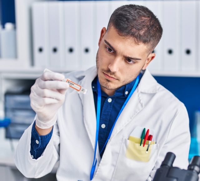 Scientist holding labeled test tube in lab