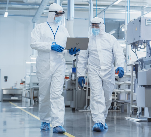 Technicians in protective suits in cleanroom
