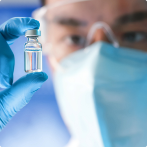 Gloved hand holding medical vial