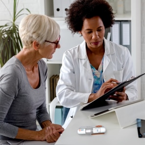 Doctor consulting patient with medical device