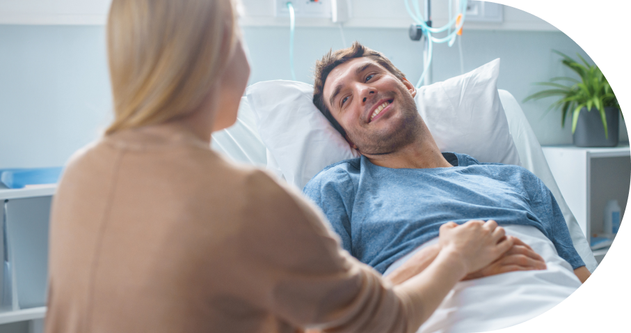 Woman comforting patient in hospital bed