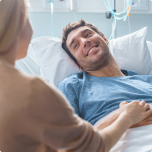Woman comforting patient in hospital bed setting