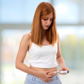 Woman self-administering injection in bright room