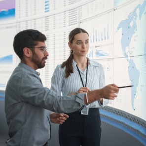 Colleagues analyzing data on digital world map display