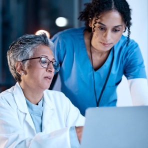 Medical professionals collaborating at computer workstation