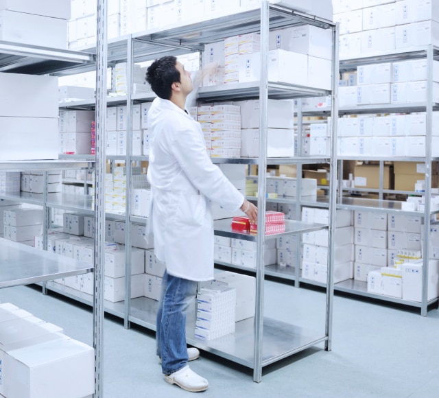 Pharmacist organizing medical inventory shelves
