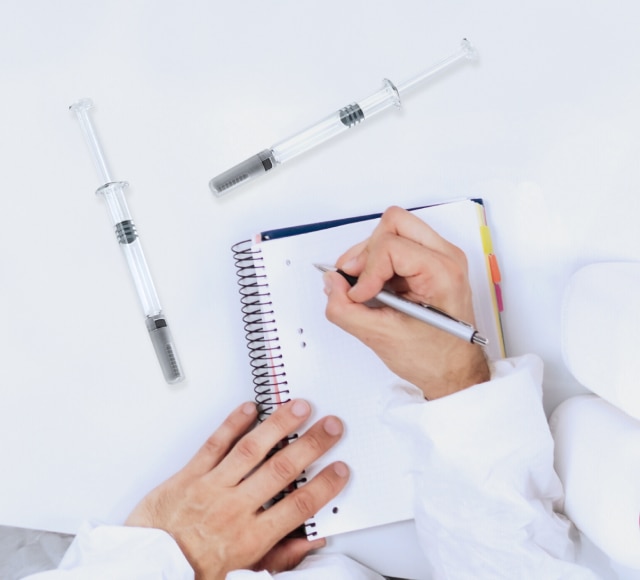 Medical syringes with person writing notes