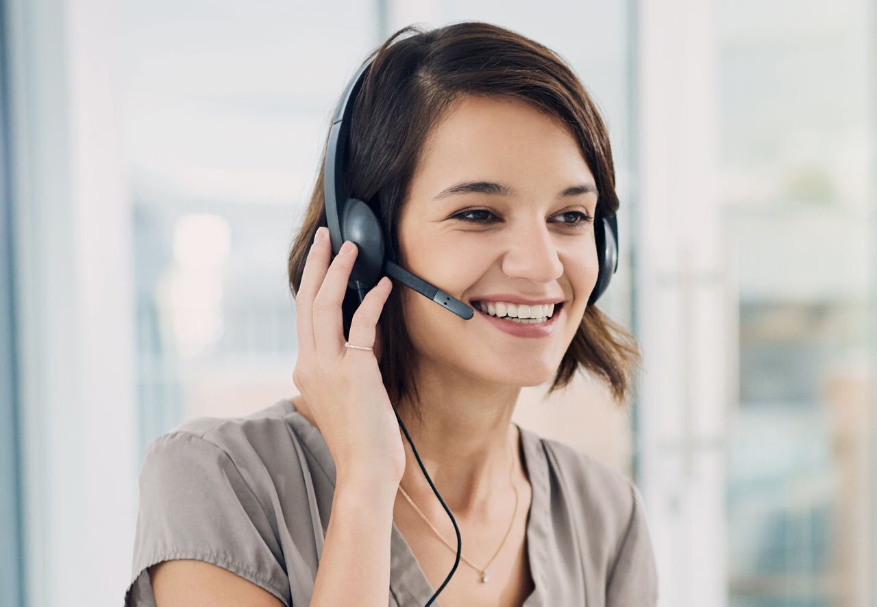 Cropped shot of an attractive young woman using a headset while sitting at her desk in the office